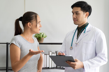 Fototapeta premium Woman discussing to the professional psychologist while standing in the office clinic. Woman has psychological trouble. Upset woman frustrated by some problem, feeling despair and anxiety.
