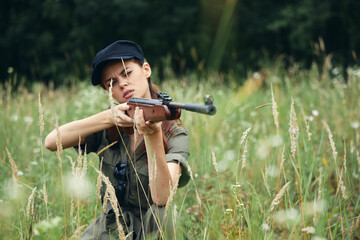 Fototapeta premium Military woman Gun in hand is a hunting lifestyle green overalls 