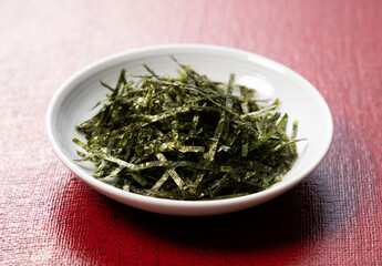 Fototapeta na wymiar Chopped seaweed on a red Japanese background
