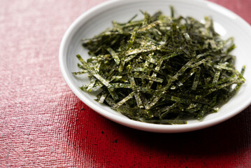 Fototapeta na wymiar Chopped seaweed on a red Japanese background