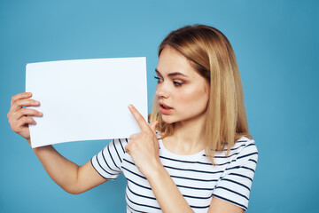 Woman holding sheet of paper striped T-shirt Copy Space cropped view blue background