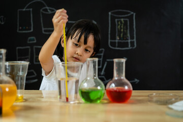 Adorable asian little girl is make easy scientific experimental about temperature measurement to cold and hot solution at home, concept of learn from home, child STEM education and science for kid.