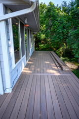 Summer construction, outdoor deck under construction, new manufactured wood planks installed
