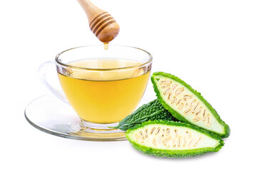 Closeup glass cup of bitter melon juice tea with honey and bitter gound slice isolated on white background. Herbal medicine plant and healthy drinks concept.