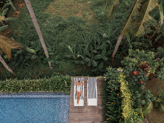 Travel and vacation. Aerial view: acute girl in white bikini is resting on a sunbed near swimming pool