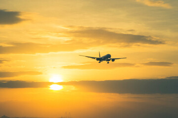 Fototapeta na wymiar aircraft landing with sun set background