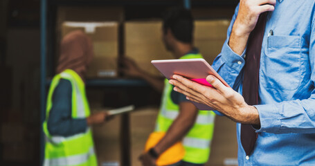 Closeup Manger hand using digital tablet over Idian worker man working with Muslim worker woman scanning bar code and QR code in local warehouse, Partner and colleague working together concept