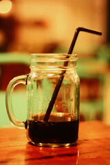 close up of glass of soda cola with straw 