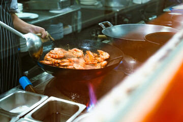 Motion Blur of chef cooking crispy spicy prawns in iron pan, Asian style food.