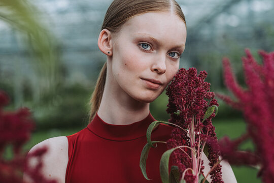 Portrait of a beautiful female holding an amaranth plant