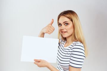 Naklejka premium woman holding a sheet of paper in her hands lifestyle striped t-shirt cropped view Copy Space