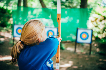 Closeup shot of a woman practicing archery - obrazy, fototapety, plakaty