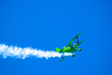 stunt plane  performing air acrobatics in the blue sky - obrazy, fototapety, plakaty