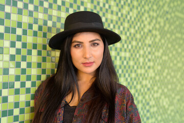 Portrait of beautiful young woman against colorful wall