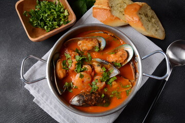 French seafood bouillabaisse soup/fish stew with mussels served with garlic toast baguette