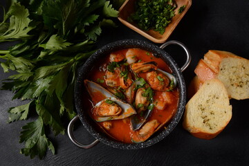 French seafood bouillabaisse soup/fish stew with mussels served with garlic toast baguette