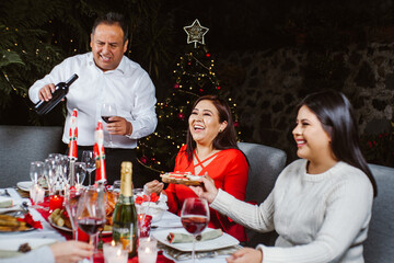 Latin family eating for Christmas and drinking wine in Mexico