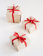 Gift boxes made from craft paper with red ribbon on white background