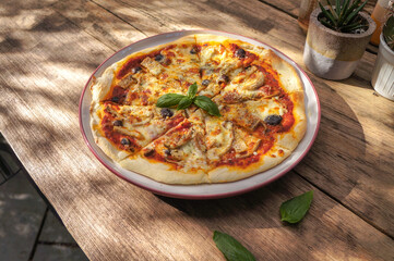 Ham and cheese pizza on a wooden table