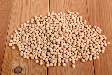 Whole yellow peas at wooden plank background