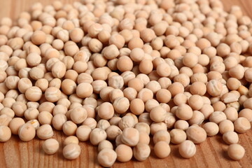 Whole yellow peas at wooden plank background