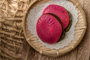 Asian Nyonya Food - kuih angku in rattan steam basket (Red Tortoise Cake traditional cake made of glutinous rice flour with red bean paste filling)