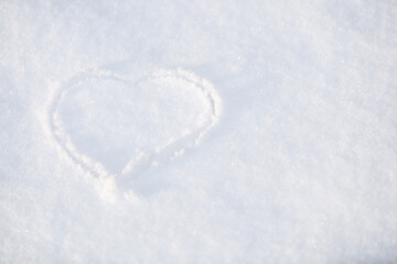 One heart in the snow. A heart is drawn on the snow close-up. The shape of heart on the snow. Winter background..