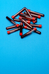 top view of medicine test tubes with blood samples over blue background