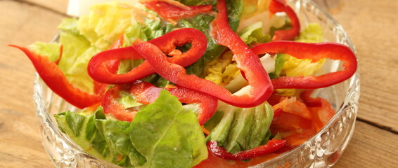 a glass bowl with fresh lettuce, bell pepper and egg