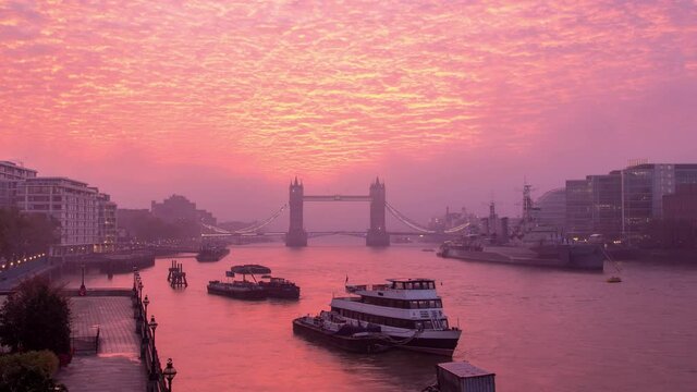 Vibrant, dramatic altocumulus sunrise clouds and fog above Tower Bridge and the River Thames in London, England