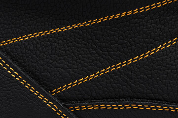 Yellow stitches on the leather of boots. Macro photo.