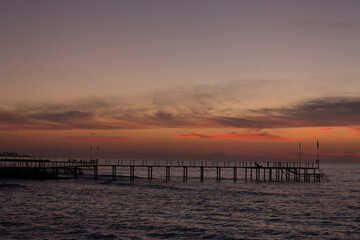 Beautiful sunset on the sea and the pier.