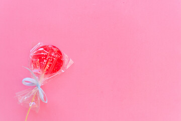 Round pink Lollipop wrapped with a bow top view with space for text. Flatly. Copy space