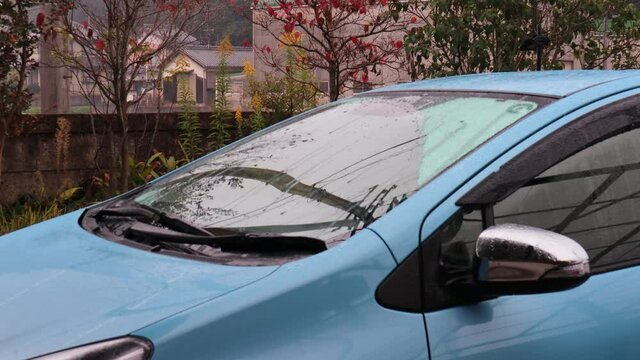 フロントガラスが水滴で覆われている雨の日に車のワイパーを1回動かす