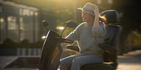 Woman tourist riding a four wheel mobility electric scooter on a city street.  © scharfsinn86