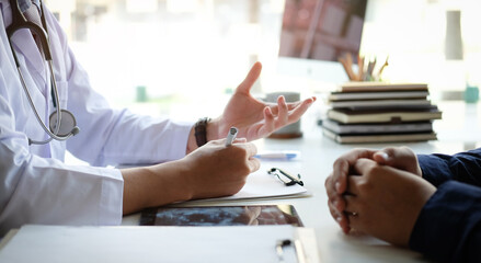 Cropped shot of a doctor is examining and consulting young man patient in hospital.