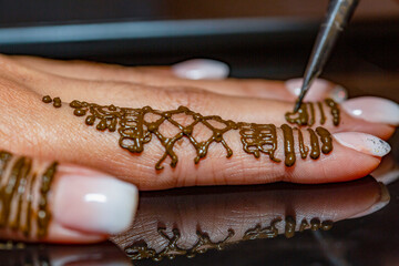 applying henna on bride's hand.