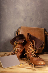 travel vintage old boots shoes at wooden desk table near concrete wall background texture surface