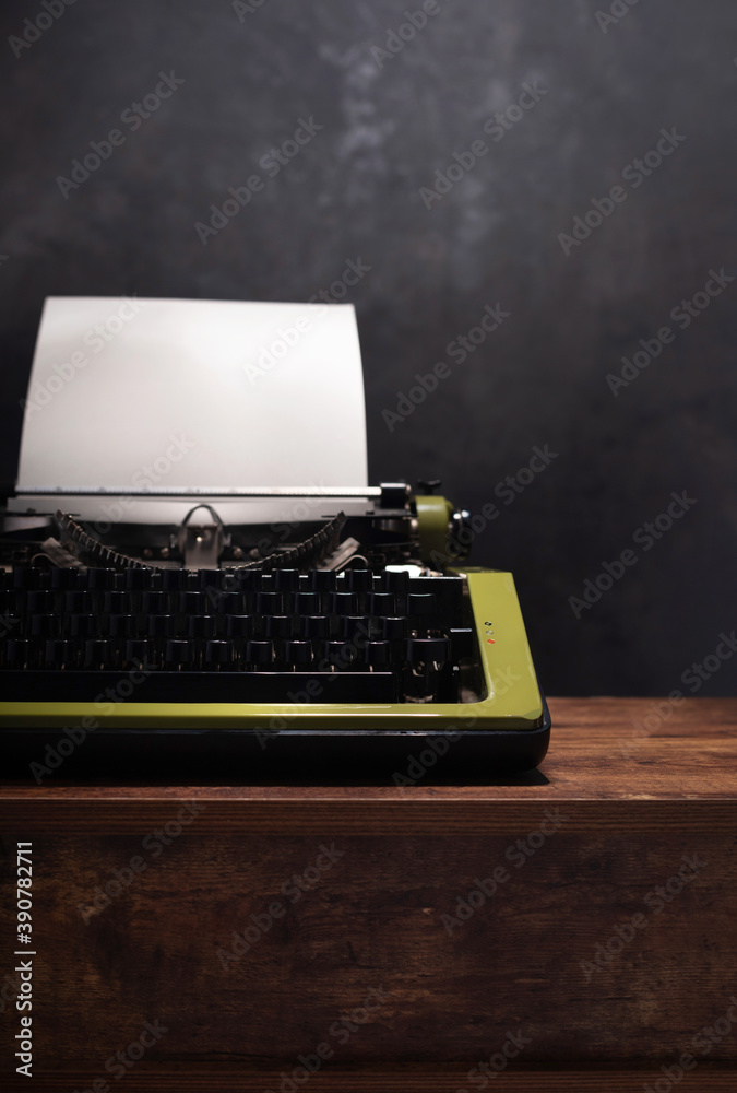 Poster vintage typewriter at wooden table near wall background surface