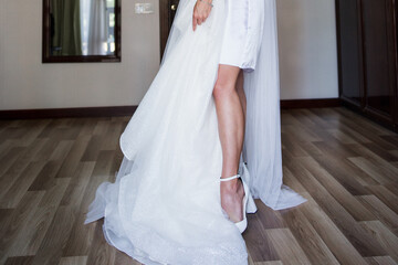 Fototapeta na wymiar a bride in a peignoir with a wedding dress