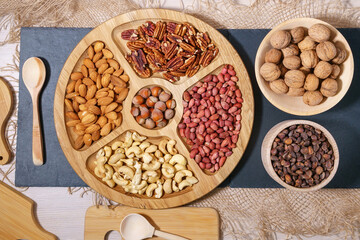 nuts peanuts, hazelnuts, almonds, cashews, walnuts, pecans on a wooden table. Top view with space for your text