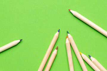 Wooden colored pencils and green background, office for children and adults