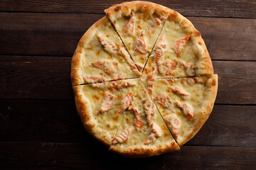 Appetizing pizza with salmon on a wooden background. Delicious food concept. Close-up.
