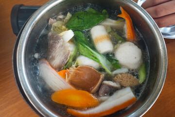 Shabu Shabu, a popular Japanese dish of beef, shrimp, squid, seafood and fresh vegetables. Placed on a table with a boiling pot.