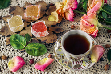 Fototapeta na wymiar delicious ,colourful retro dessert of marmalade and a Cup of rose hip tea