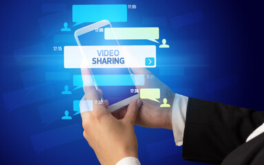 Female hand typing on smartphone with VIDEO SHARING inscription, social networking concept
