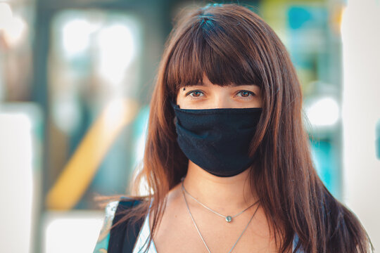 Portrait Of A Young Brunette Woman In A Black Medical Mask. Outdoor. Protection Against Viruses And Allergies