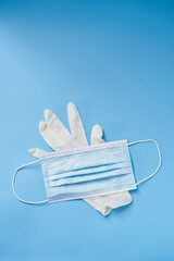 Isolated glove and face mask on a blue background. Protection during Covid-19 quarantine