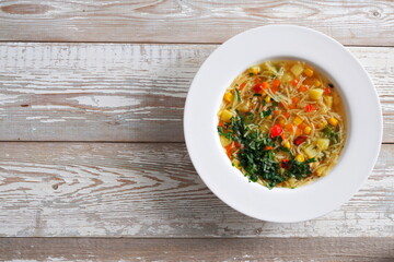 Vegetarian vegetable noodle soup on a rustic wooden table. Healthy diet food. Top view. Copy space.