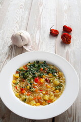 Vegetarian vegatable soup with noodles on rustic wooden table. Healthy diet food.